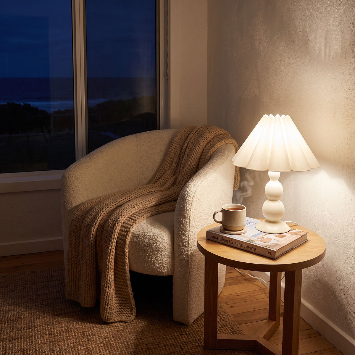 Scalloped Pleated Shade Bobbin Table Lamp in white on a side table beside an armchair in a living room reading corner
