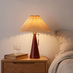 Pleated Shade Cone Wood Base Pull Chain Table Lamp on a bedside table