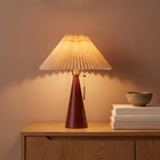 Pleated shade table lamp with walnut cone base on an oak sideboard