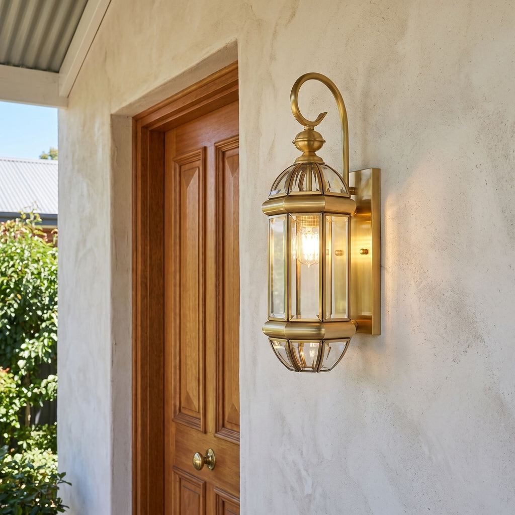 Polished Brass Clear Glass Outdoor Wall Light beside a timber front door