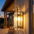 Polished Brass Clear Glass Outdoor Wall Light on a porch wall at dusk