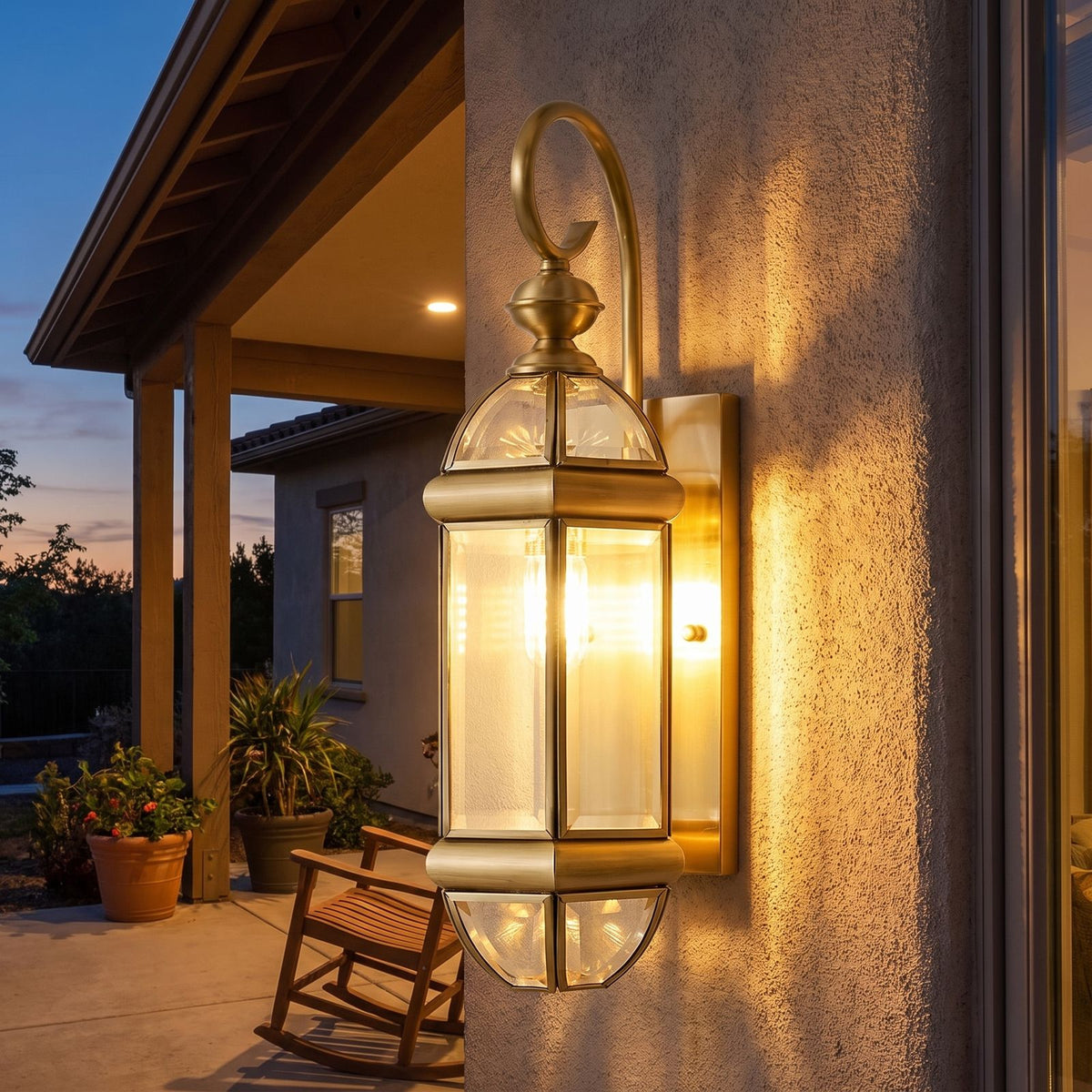 Polished Brass Clear Glass Outdoor Wall Light on a porch wall at dusk