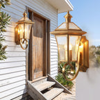 Polished Brass Coastal Outdoor Wall Lantern beside a timber front door
