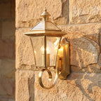 Polished Brass Coastal Outdoor Wall Lantern, close view at 45 degrees on a stone wall