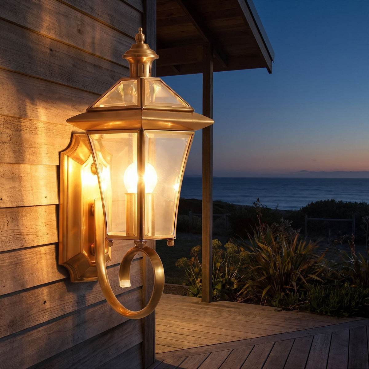 Polished Brass Coastal Outdoor Wall Lantern on a porch wall at dusk