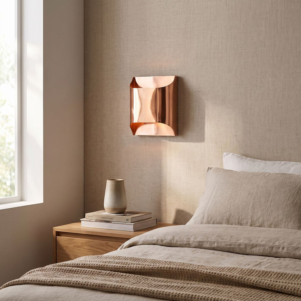 Polished Copper Double LED Wall Light on a bedroom wall beside the bed