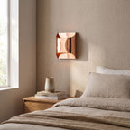 Polished Copper Double LED Wall Light on a bedroom wall beside the bed
