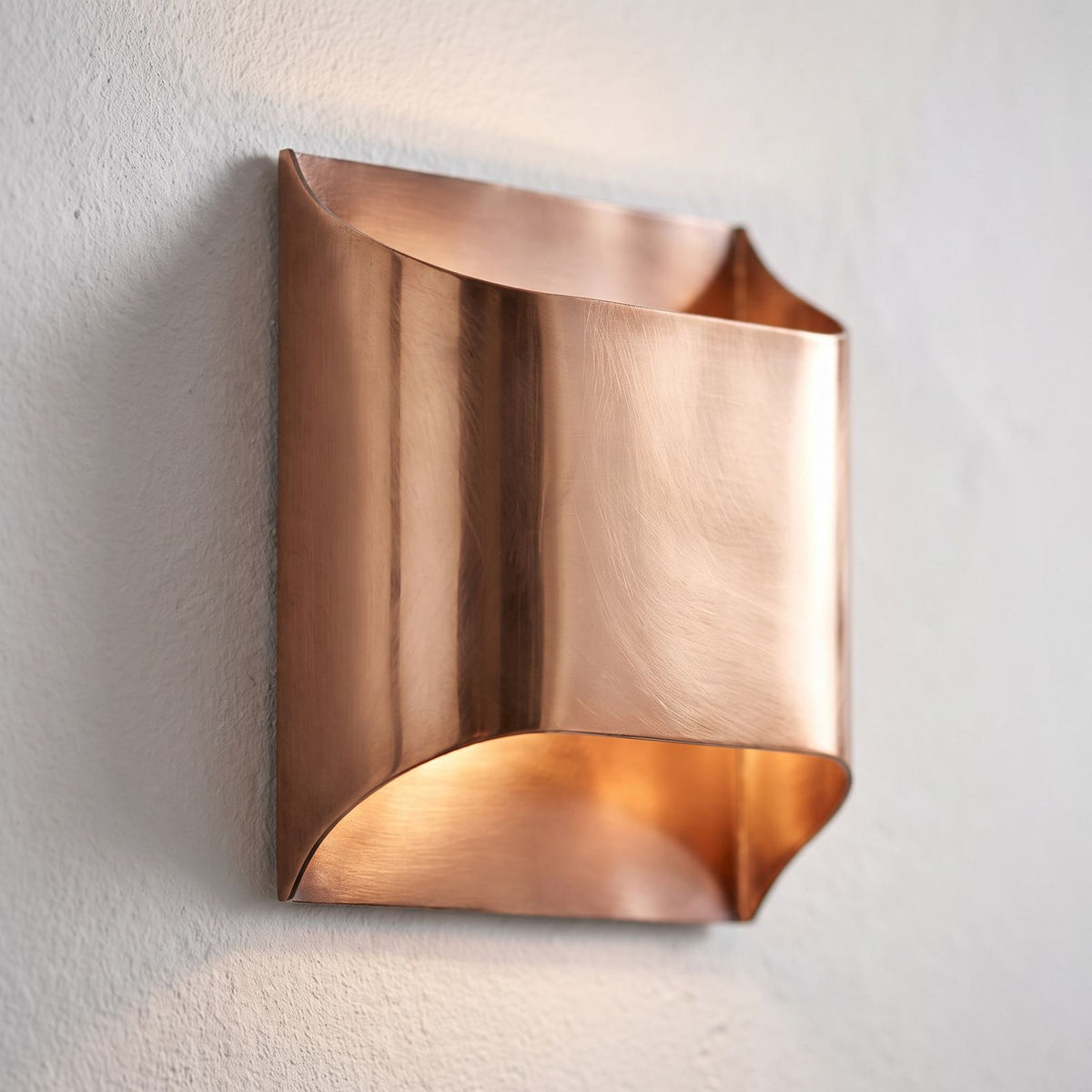 Polished Copper Double LED Wall Light, close view at 45 degrees on a plaster wall