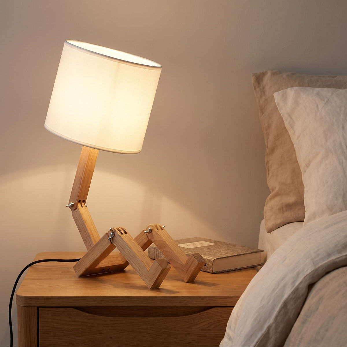 Poseable Wooden Figure Fabric Shade Table Lamp on a bedside table