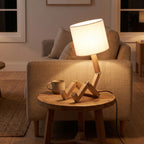 Poseable wooden figure table lamp on a side table beside a sofa