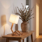 Poseable wooden figure table lamp on an entry console