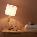 Poseable wooden figure table lamp on an oak sideboard
