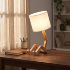 Poseable wooden figure table lamp on a home office desk