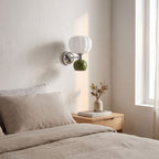 Pumpkin Shade Chrome Wall Sconce on a bedroom wall beside the bed
