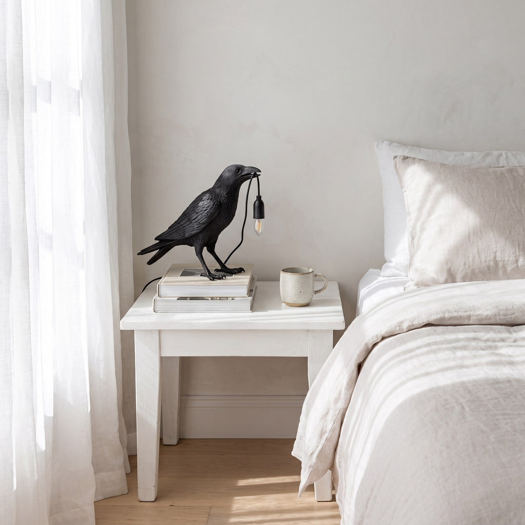 Raven Sculpture Resin Table Lamp on a bedside table in a coastal bedroom