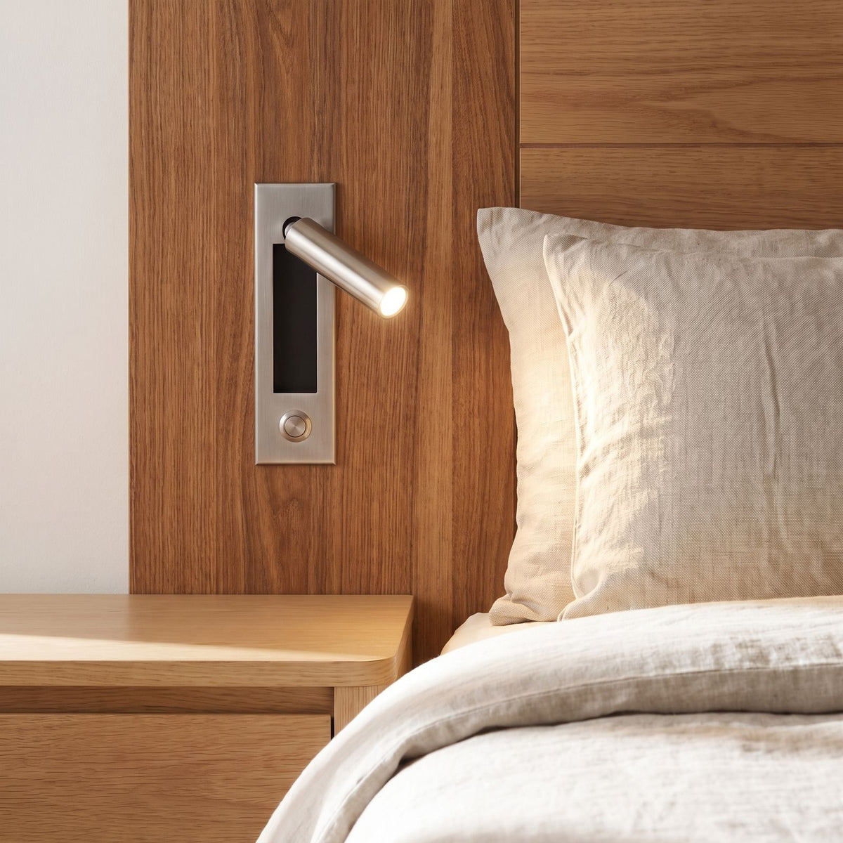 Recessed swivel tube reading wall light in a timber bedhead in daylight