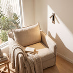 Recessed swivel tube reading wall light beside a reading armchair in daylight