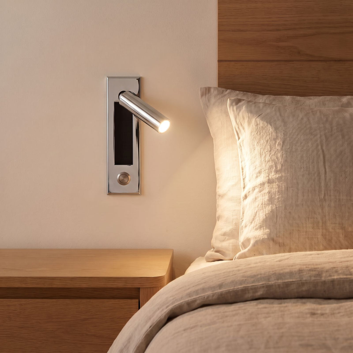Recessed Swivel Tube Bedside Reading Wall Light in chrome beside a bed