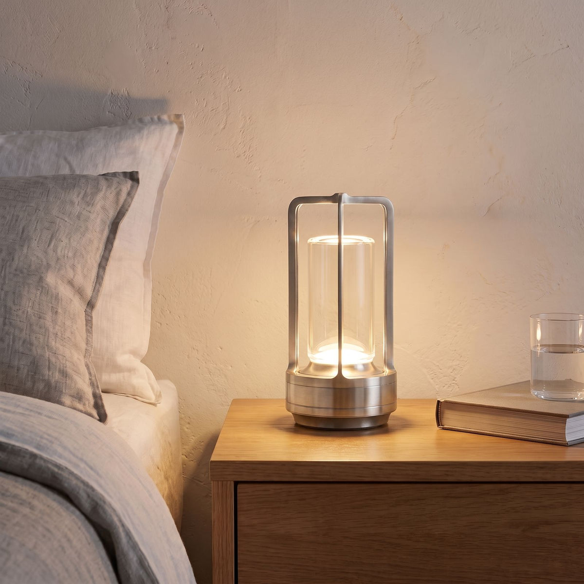 Rechargeable Clear Cylinder Lantern Table Lamp in silver on a bedside table