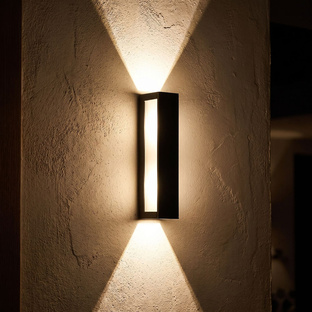 Rectangular Aluminium and Glass Up-Down Wall Light glowing on a plaster wall at night