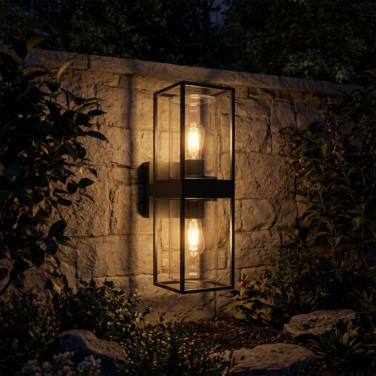 Rectangular Black Metal and Glass Outdoor Wall Light glowing on a garden wall at night