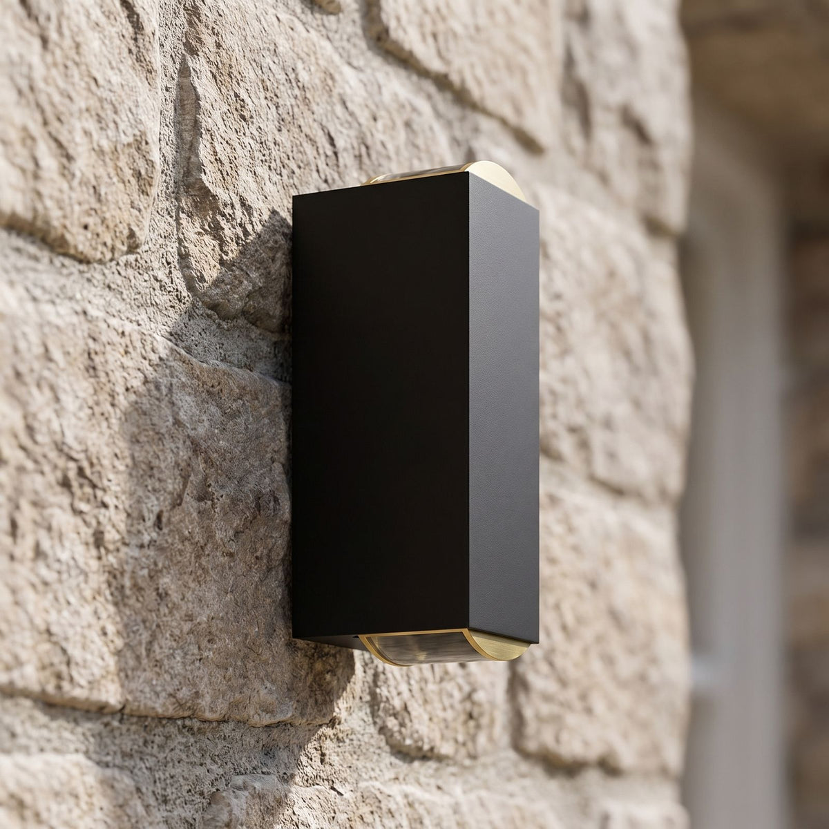 Rectangular Metal Up Down Outdoor Wall Light, close view at 45 degrees on a stone wall