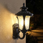 Retro Black Frosted Glass Outdoor Wall Light glowing on a garden wall at night