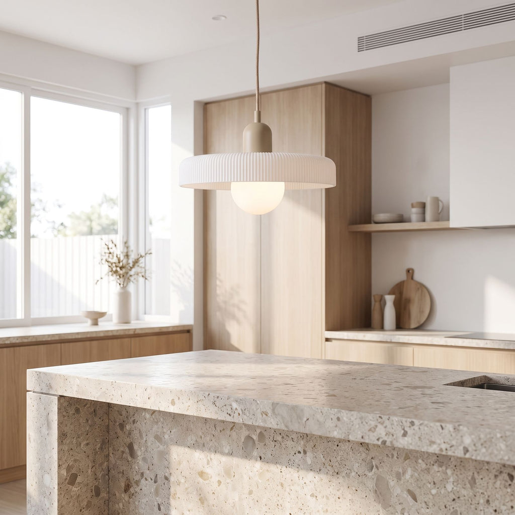 Ribbed disc and matte glass pendant light over a kitchen island in daylight