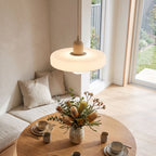 Ribbed disc and matte glass pendant light over a breakfast table in daylight