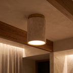 Retro Travertine Shade and Wood Base Ceiling Light glowing on a ceiling at night