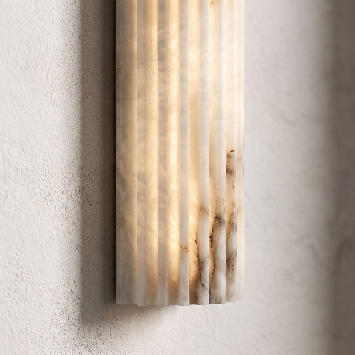 Ribbed Alabaster Column LED Wall Light, close view at 45 degrees on a plaster wall