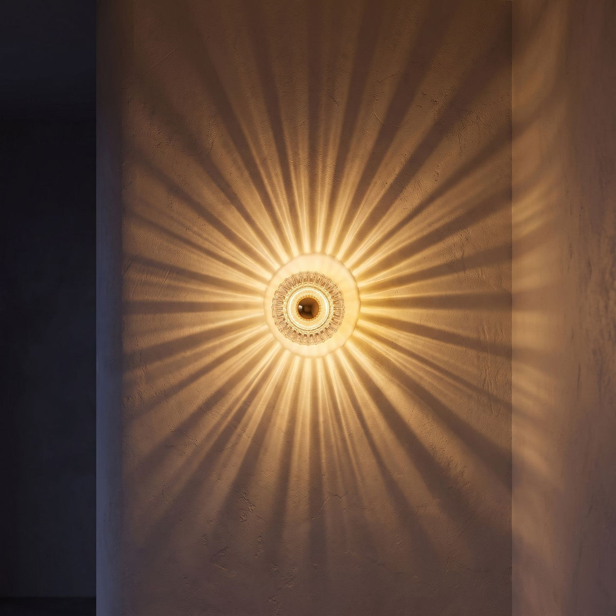 Ribbed glass barrel shade wall light in a hallway at night