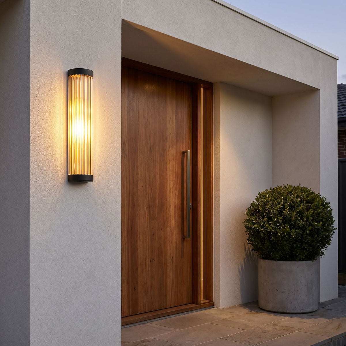 Ribbed Glass Cylinder Outdoor Wall Light beside a timber pivot door on a rendered wall
