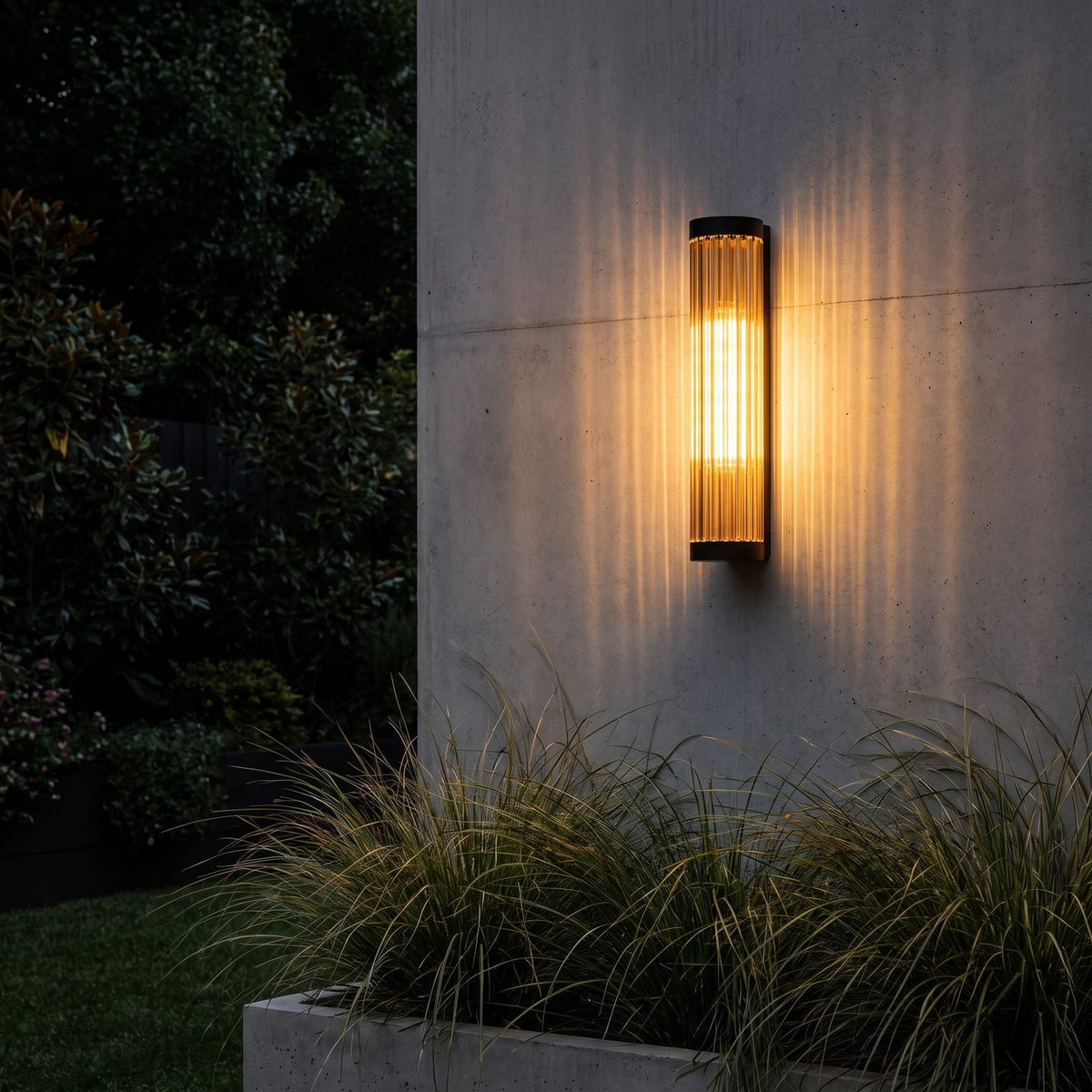 Ribbed Glass Cylinder Outdoor Wall Light lighting a concrete wall at night