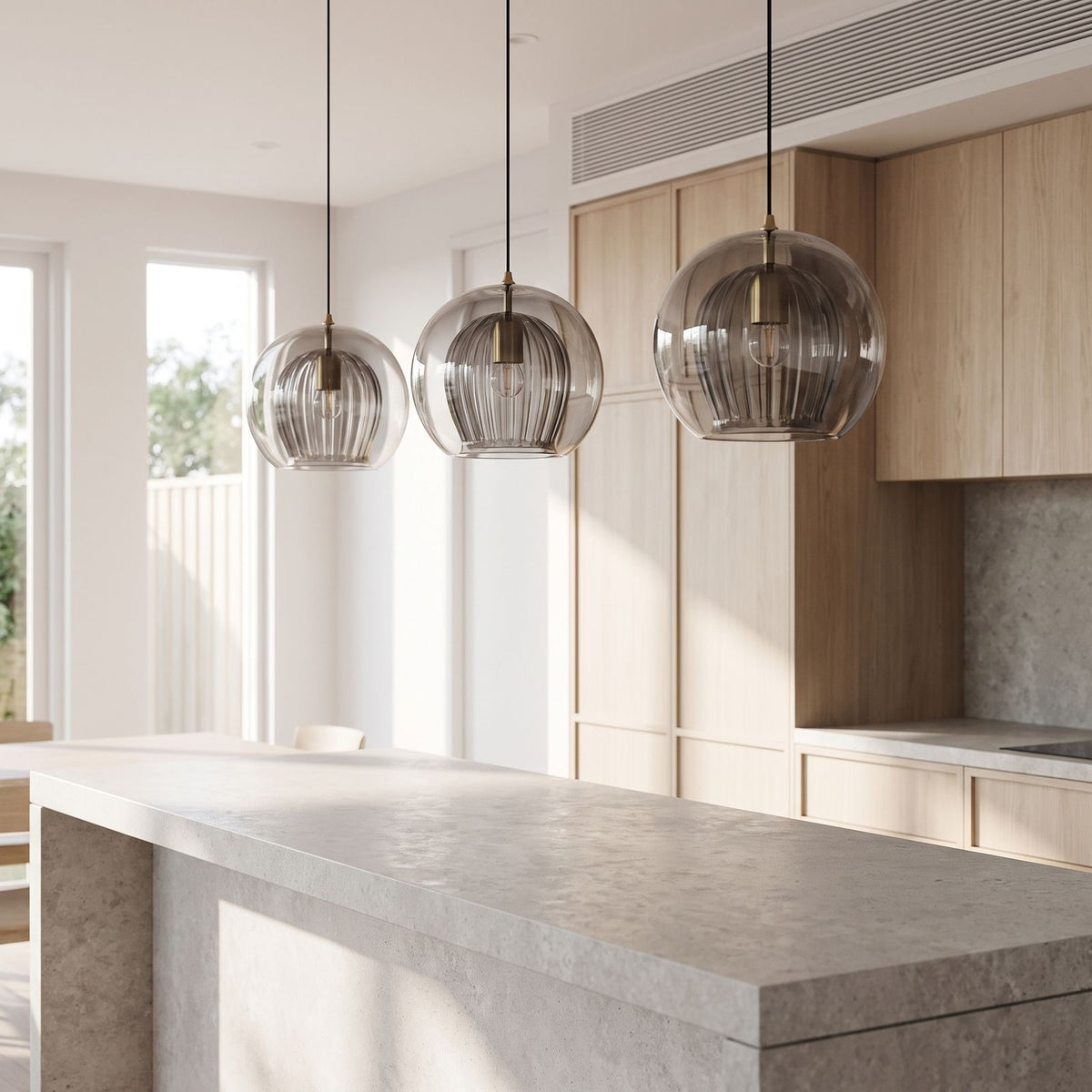 Ribbed Glass Globe Pendant Light in a row of three over a stone kitchen island