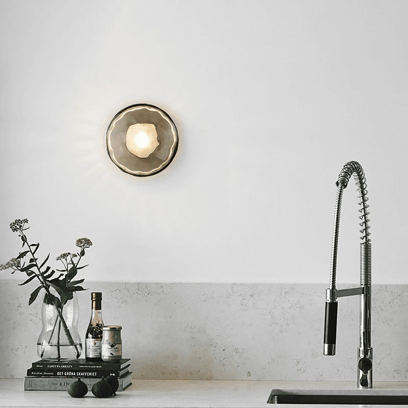 Glass disc wall light above a kitchen benchtop