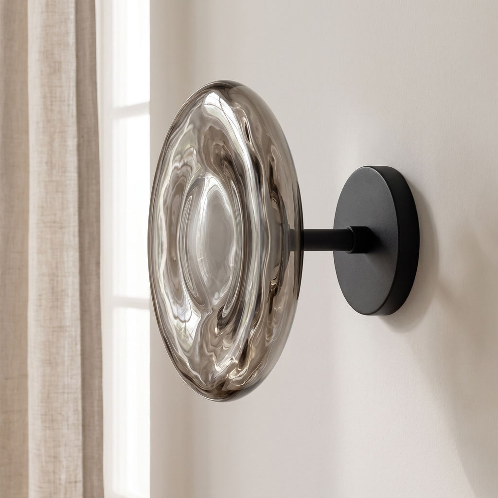 Rippled Smoked Glass Disc Wall Light on a plaster wall in daylight