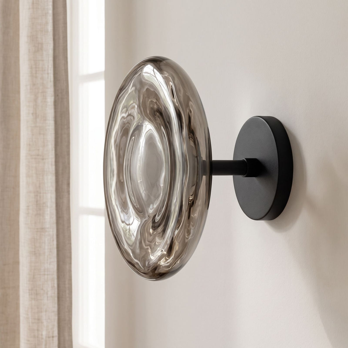 Rippled Smoked Glass Disc Wall Light on a plaster wall in daylight