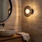 Rippled Smoked Glass Disc Wall Light in a travertine powder room