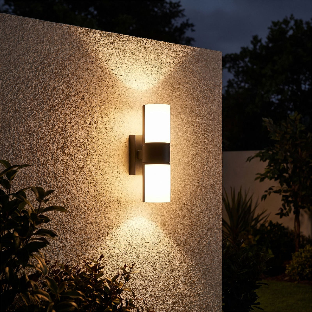Rotatable Metal Band Acrylic Cylinder LED Outdoor Wall Light glowing on a garden wall at night
