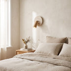 Rotatable Travertine Spotlight Wall Light on a bedroom wall beside the bed