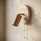 Rotatable Travertine Spotlight Wall Light, close view at 45 degrees on a plaster wall