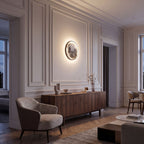 Round 3D Moon Black Frame LED Wall Light in warm white on a panelled living room wall above a walnut sideboard in the evening