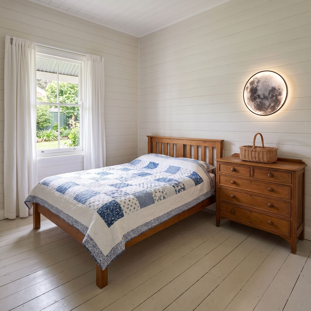 The 3D moon wall light above a timber chest of drawers in a cottage bedroom by day