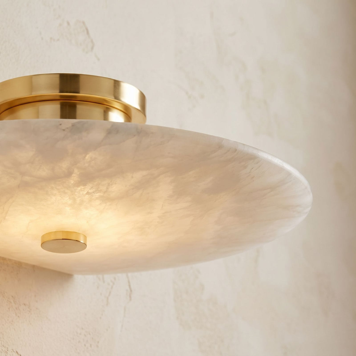 Round Alabaster Flush Wall and Ceiling Light, close view at 45 degrees on a plaster wall