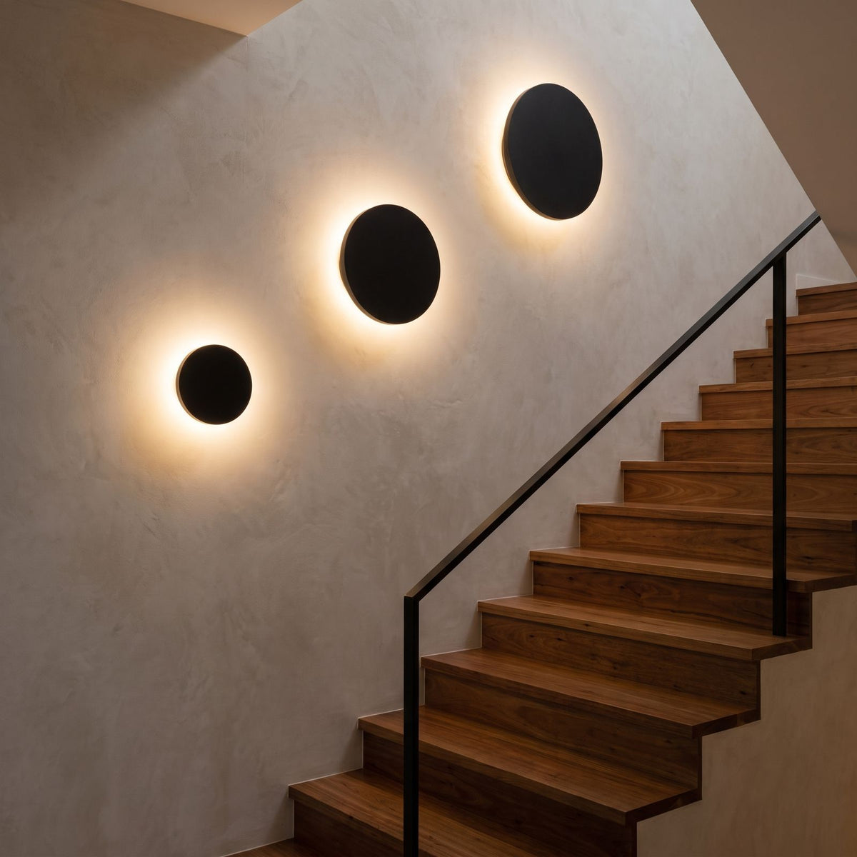 Three Round Aluminium Disc LED Wall Lights up a stairwell wall