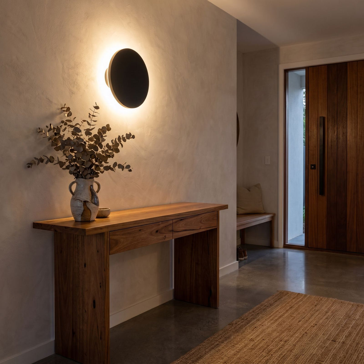 Round Aluminium Disc LED Wall Light above a timber console in an entry hallway