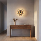 Round Glass Dish LED Wall Light in a hallway above a timber console