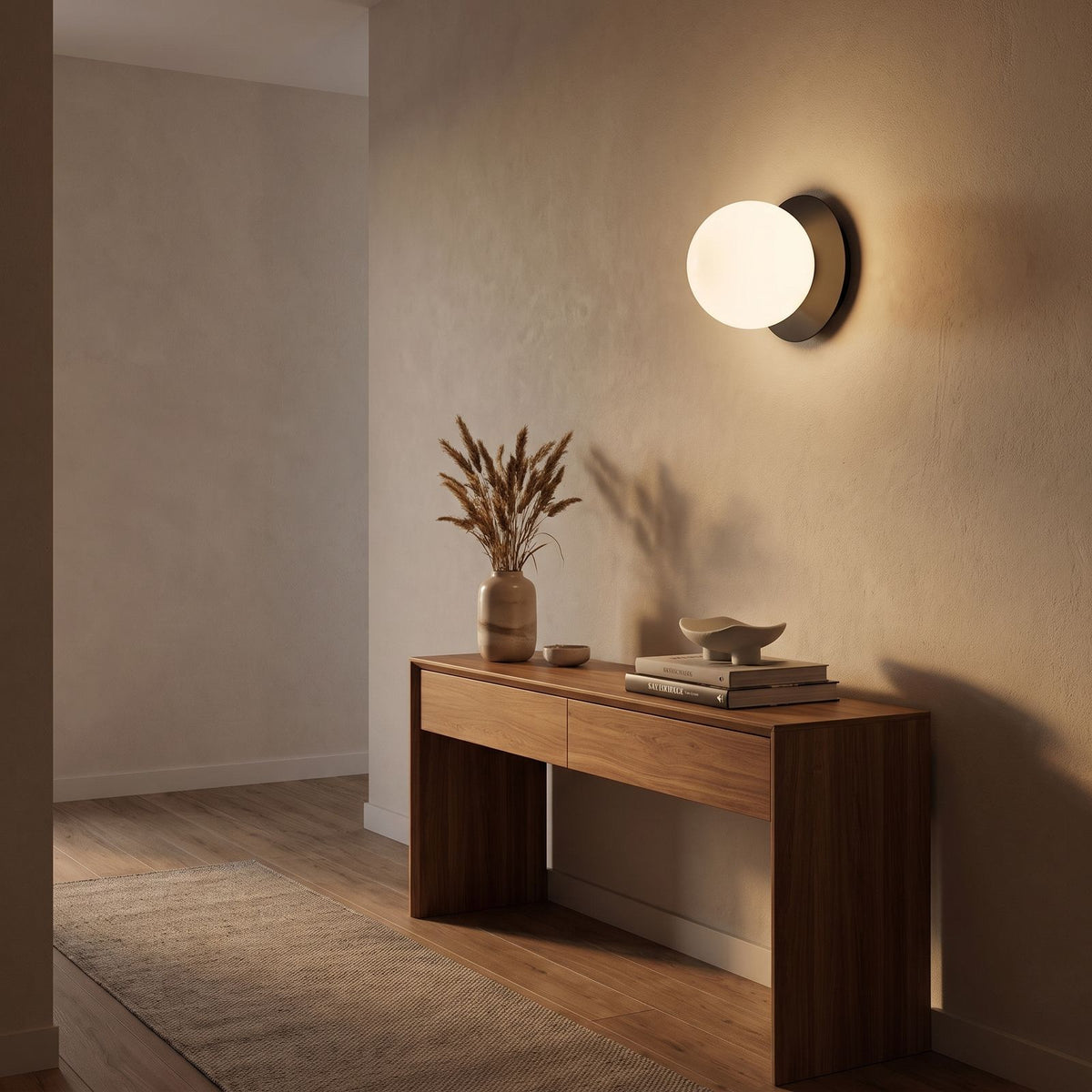 Round Glass Wall Sconce with Metal Backplate in a hallway above a timber console