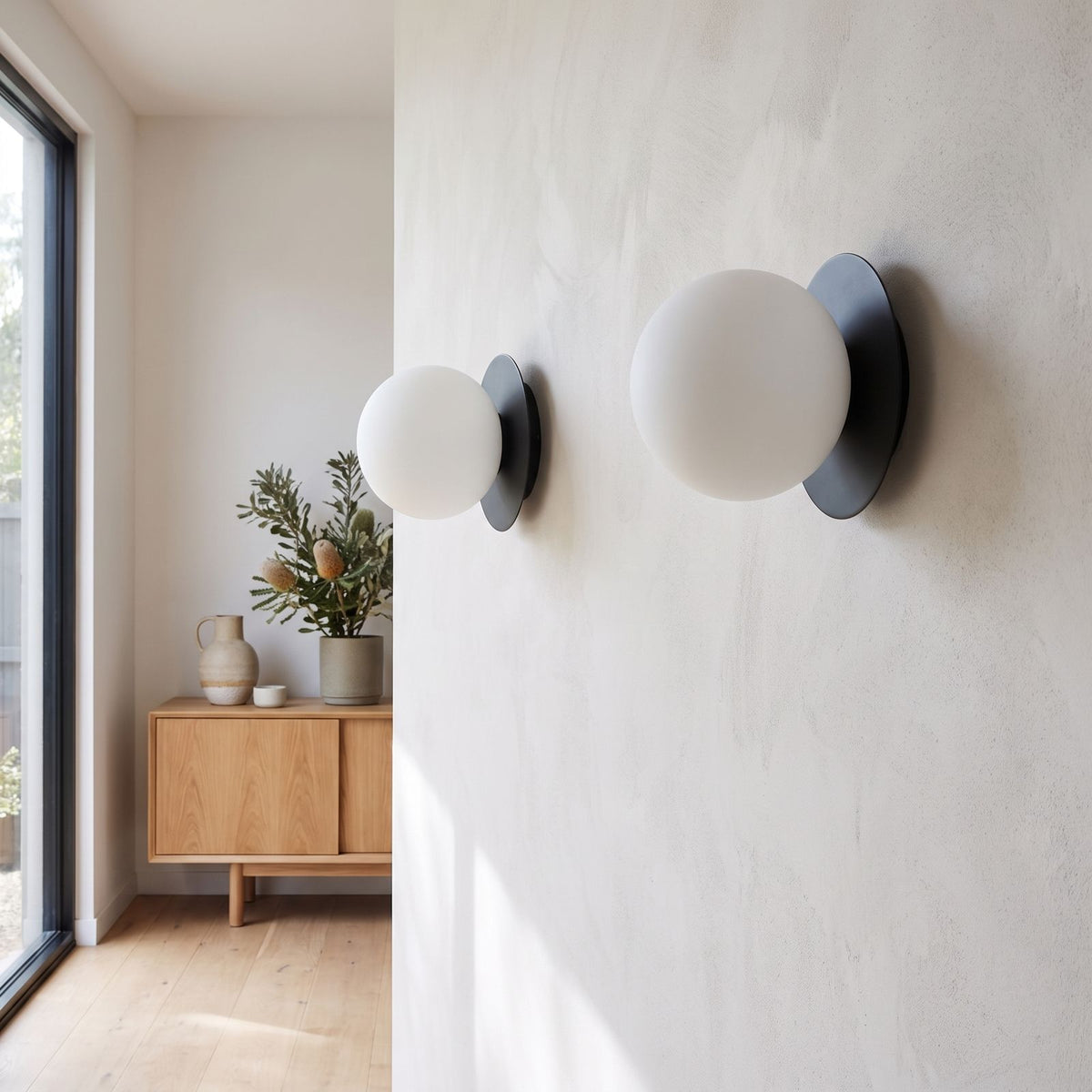 Round Glass Wall Sconce with Metal Backplate in a pair on a wall of an Australian home